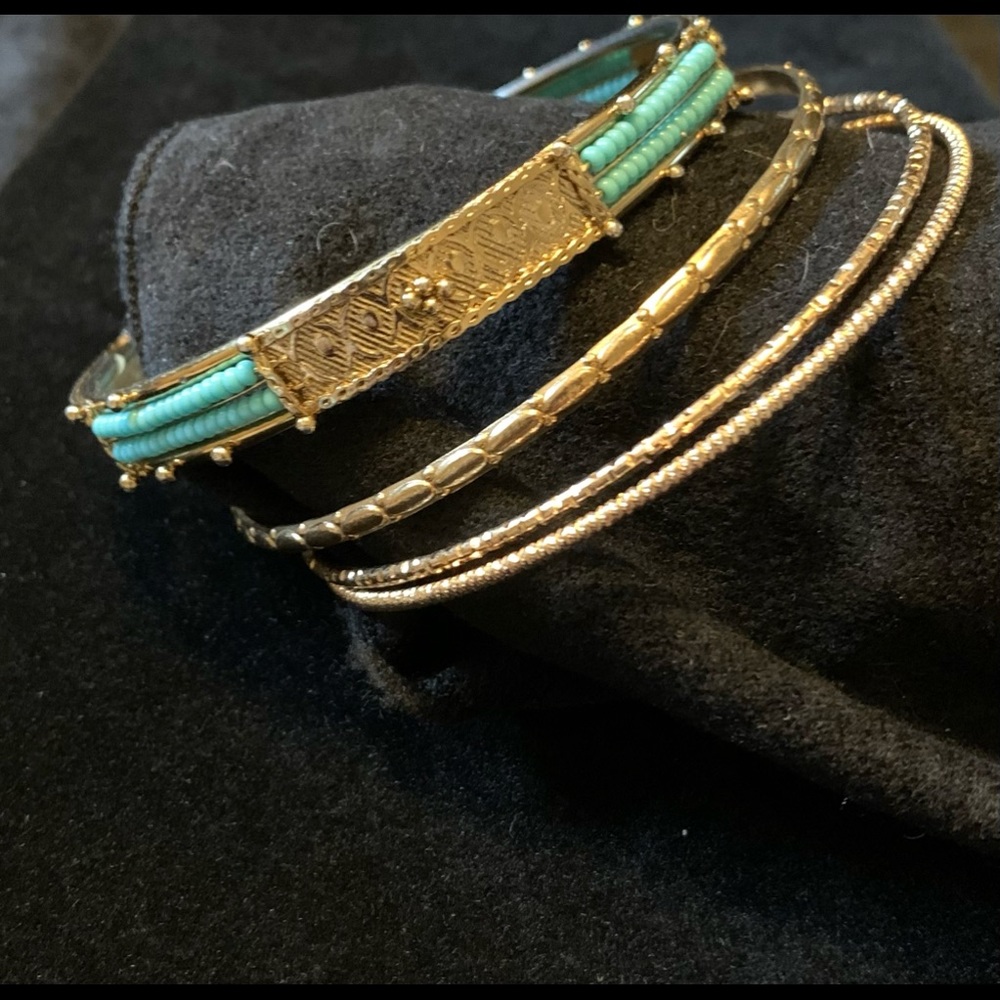 4 gold tone bangle bracelets. 1 w/turquoise seed beads 1/4” wide, 2.5” diameter